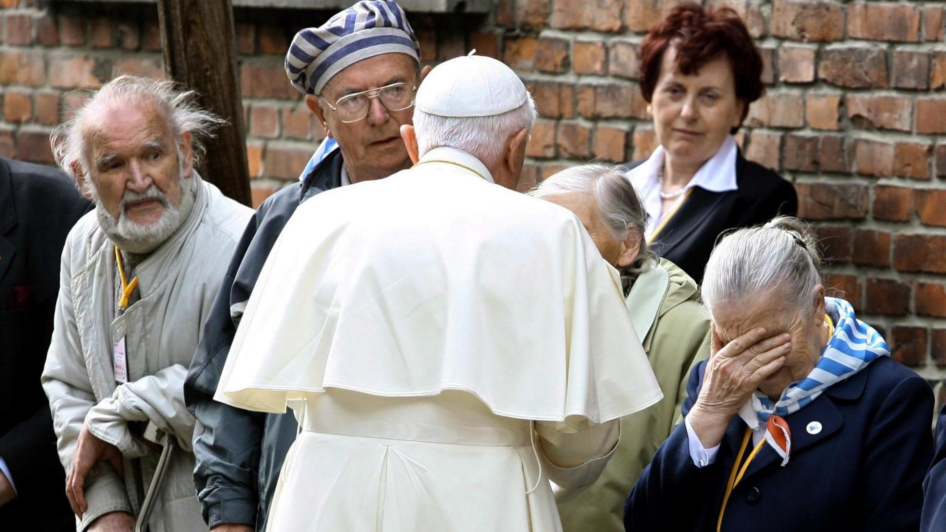 Papst Benedikt XVI. während eines Treffens mit ehemaligen Häftlingen an der "Schwarzen Wand" im Block 11 des ehemaligen Vernichtungslager Auschwitz-Birkenau am 28. Mai 2006. Papst Benedikt XVI. während eines Treffens mit ehemaligen Häftlingen an der "Schwarzen Wand" im Block 11 des ehemaligen Vernichtungslager Auschwitz-Birkenau am 28. Mai 2006.