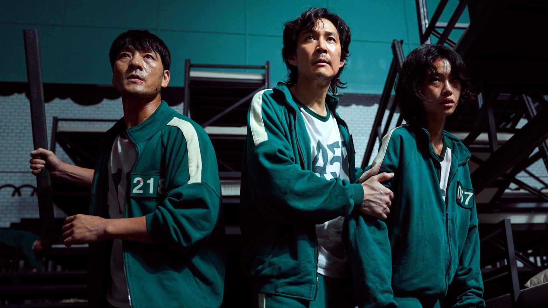 Szene aus dem Überlebenskampfspiel "Squid Game" mit: Lee Jung-jae, Greg Chun, Stephen Fu. Netflix Serie aus Südkorea, 2021. Szene aus dem Überlebenskampfspiel "Squid Game" mit: Lee Jung-jae, Greg Chun, Stephen Fu. Netflix Serie aus Südkorea, 2021.