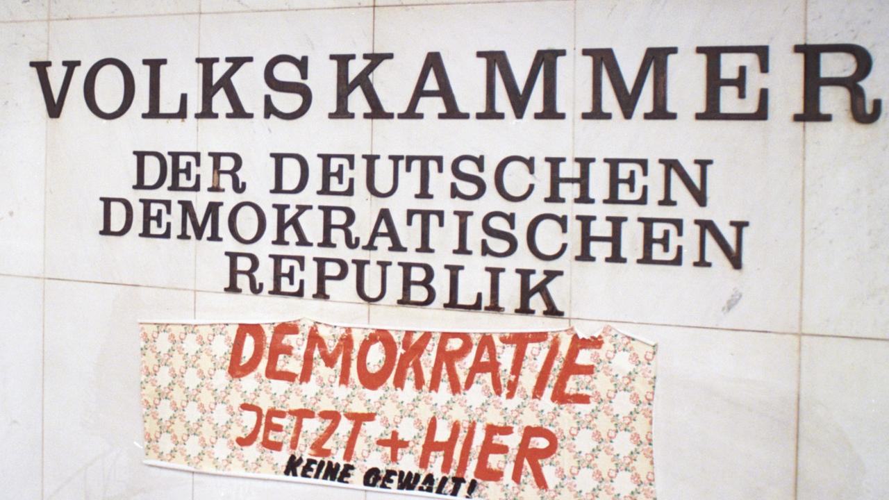 Ein Stück Tapete mit dem Spruch "Demokratie jetzt und hier" klebt am 4.11.1989 am Palast der Republik in Ost-Berlin.