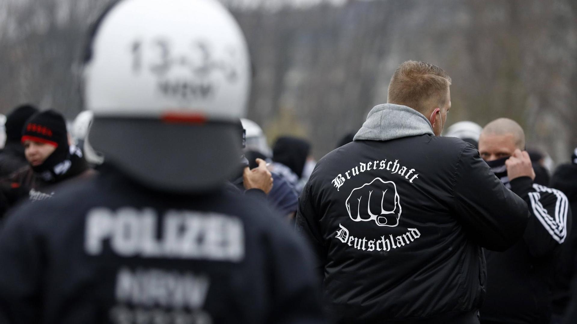 Polizisten kesseln eine Gruppe Hooligans auf der Querdenken-Demo im Rheinpark Golzheim ein. Ein Demonstrant trägt eine Jacke mit der Aufschrift "Bruderschaft Deutschland": Eine neonazistische Gruppierung, die hauptsächlich in Düsseldorf tätig ist. Polizisten kesseln eine Gruppe Hooligans auf der Querdenken-Demo im Rheinpark Golzheim ein. Ein Demonstrant trägt eine Jacke mit der Aufschrift "Bruderschaft Deutschland": Eine neonazistische Gruppierung, die hauptsächlich in Düsseldorf tätig ist.