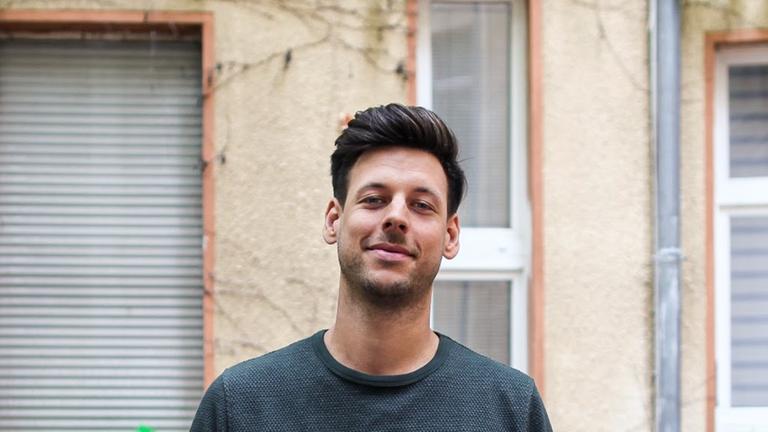Marcel Sonneck, ein junger Mann, schaut freundlich in die Kamera.