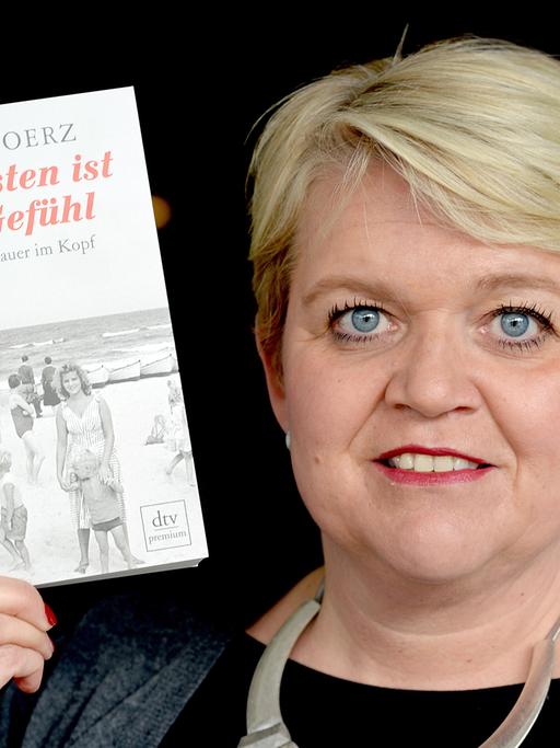 Die Autorin Anja Goerz posiert am 15.04.2014 in Kleinmachnow (Brandenburg) mit ihrem Buch "Der Osten ist ein Gefühl".
