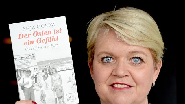 Die Autorin Anja Goerz posiert am 15.04.2014 in Kleinmachnow (Brandenburg) mit ihrem Buch "Der Osten ist ein Gefühl".
