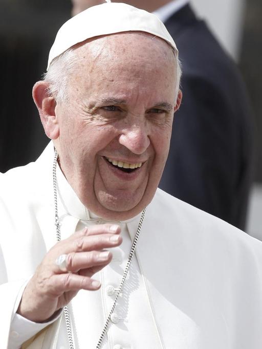 Der Papst lächelt im Vatikan.
