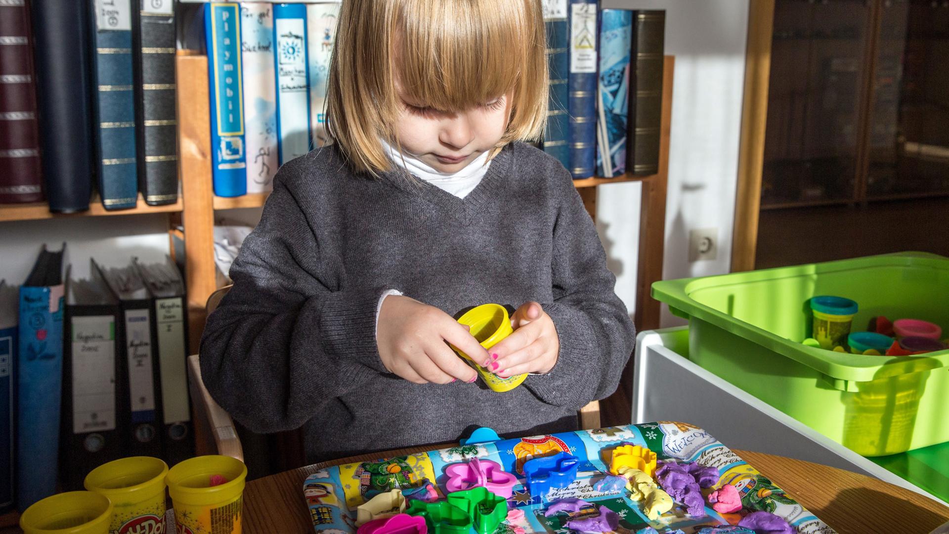 Ein vierjähriges Mädchen beim Kneten Ein vierjähriges Mädchen beim Kneten