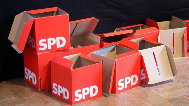 Leere Stimmzettel-Boxen stehen beim SPD-Landesparteitag vor der Bühne.