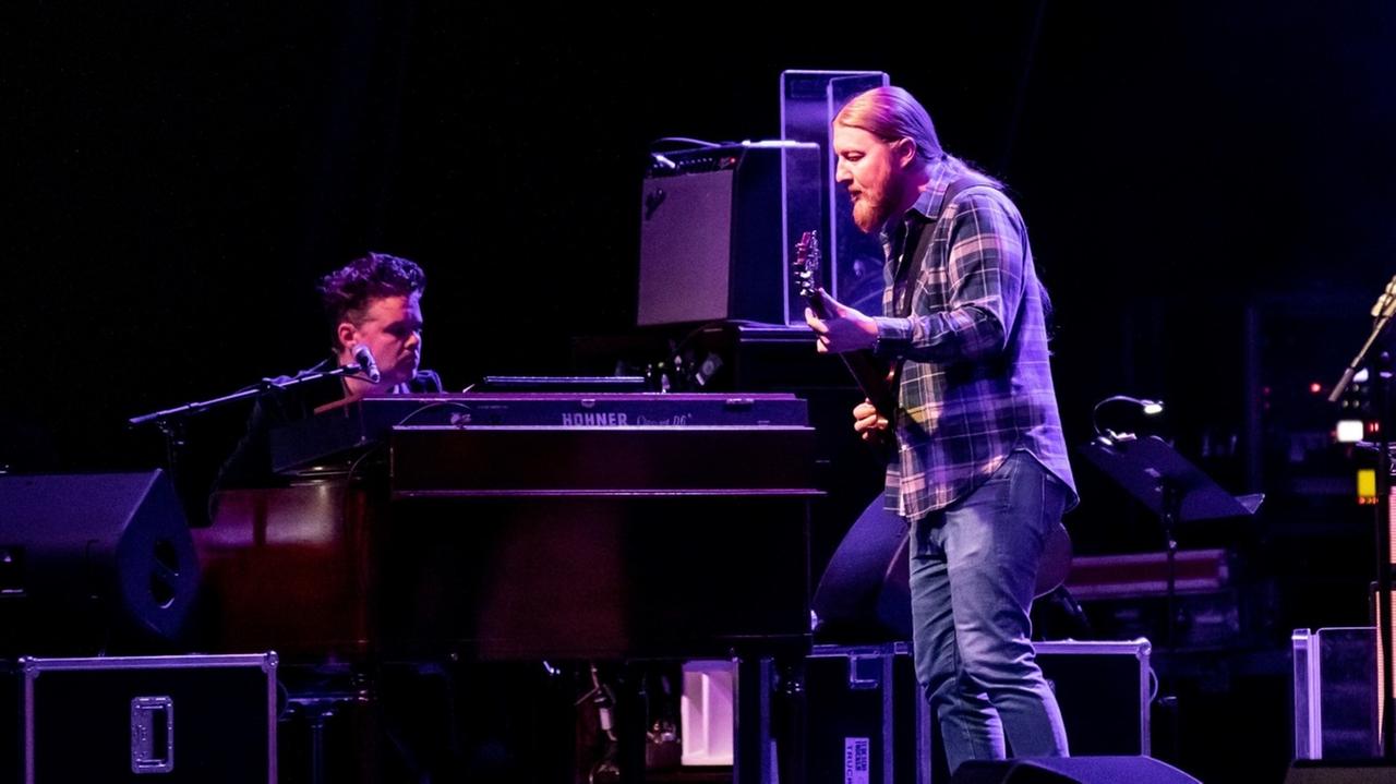 Derek Trucks steht auf einer Bühne und spielt Gitarre Derek Trucks steht auf einer Bühne und spielt Gitarre