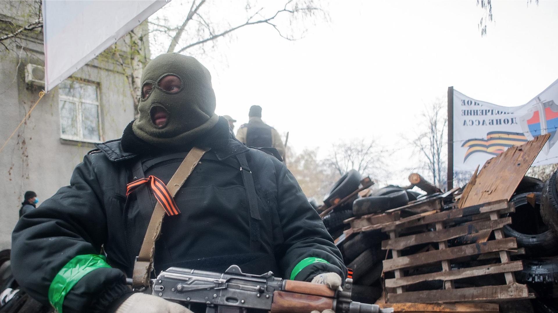Ein bewaffneter prorussischer Aktivist vor einer Barrikade in Slawjansk.