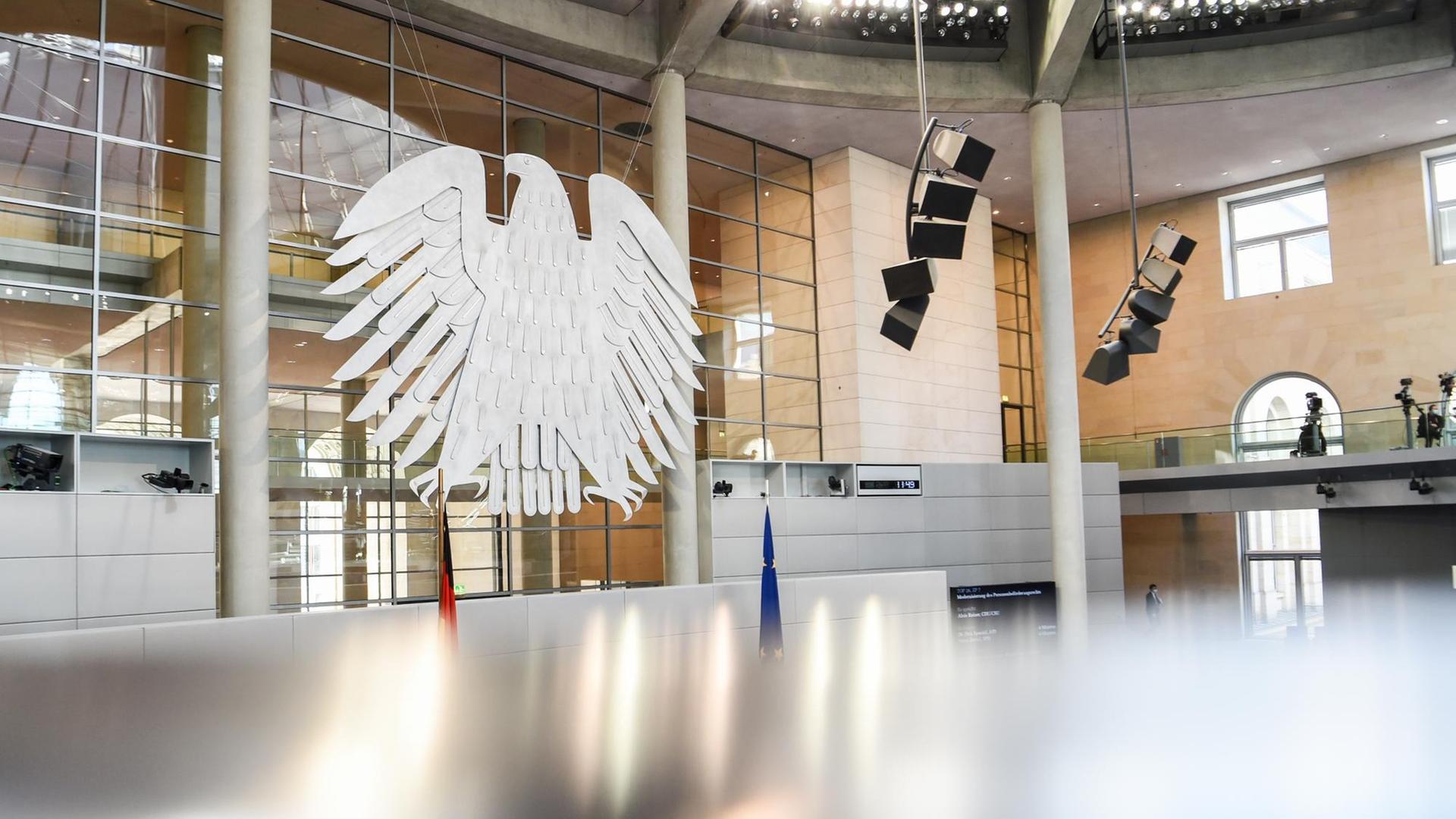 Verschwommener Vordergrund, im Hintergrund der Bundesadler im Plenarsaal des deutschen Bundestags