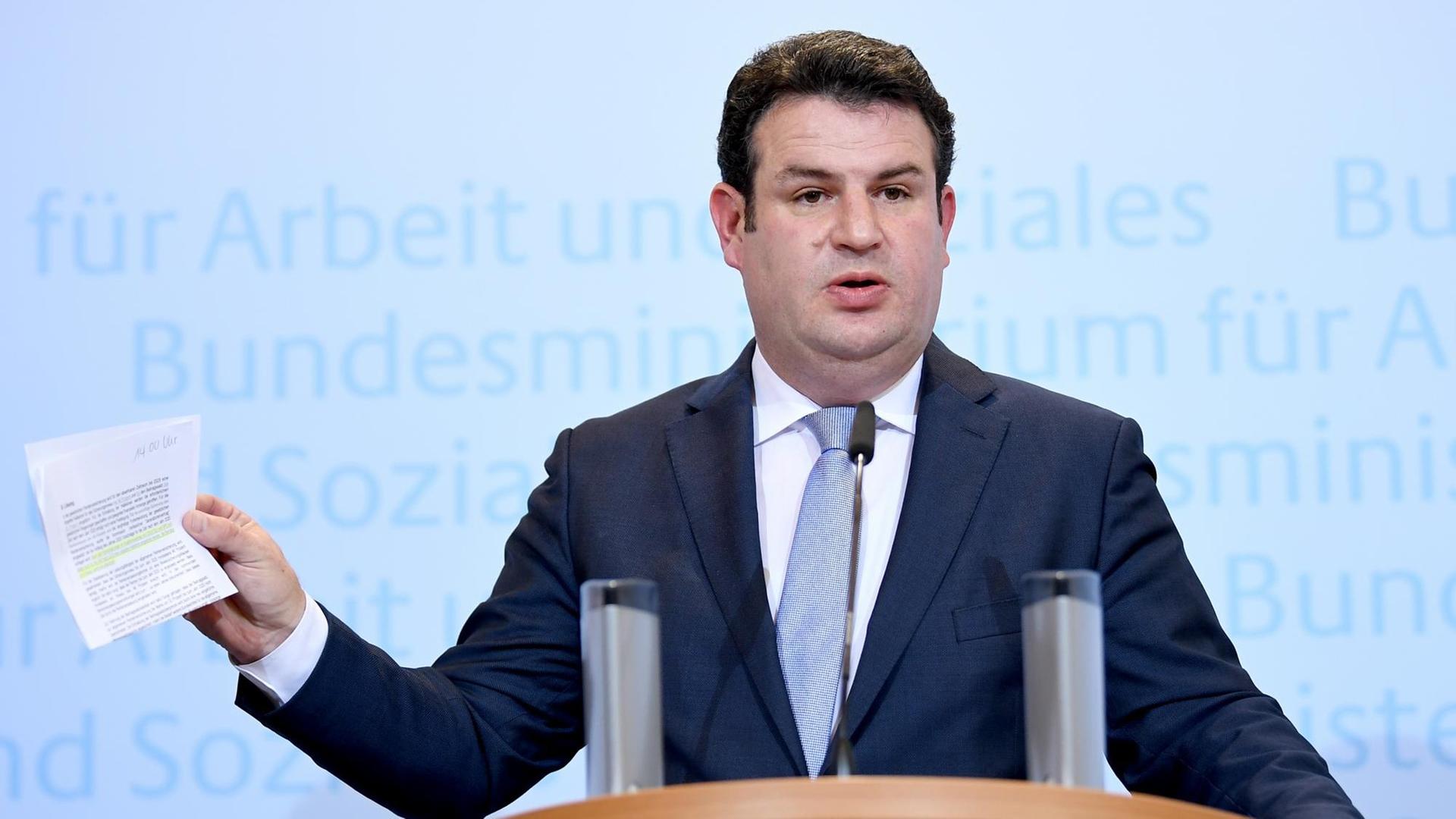 Hubertus Heil steht an einem Redepult seines Ministeriums für Arbeit und Soziales und spricht. Hubertus Heil steht an einem Redepult seines Ministeriums für Arbeit und Soziales und spricht.