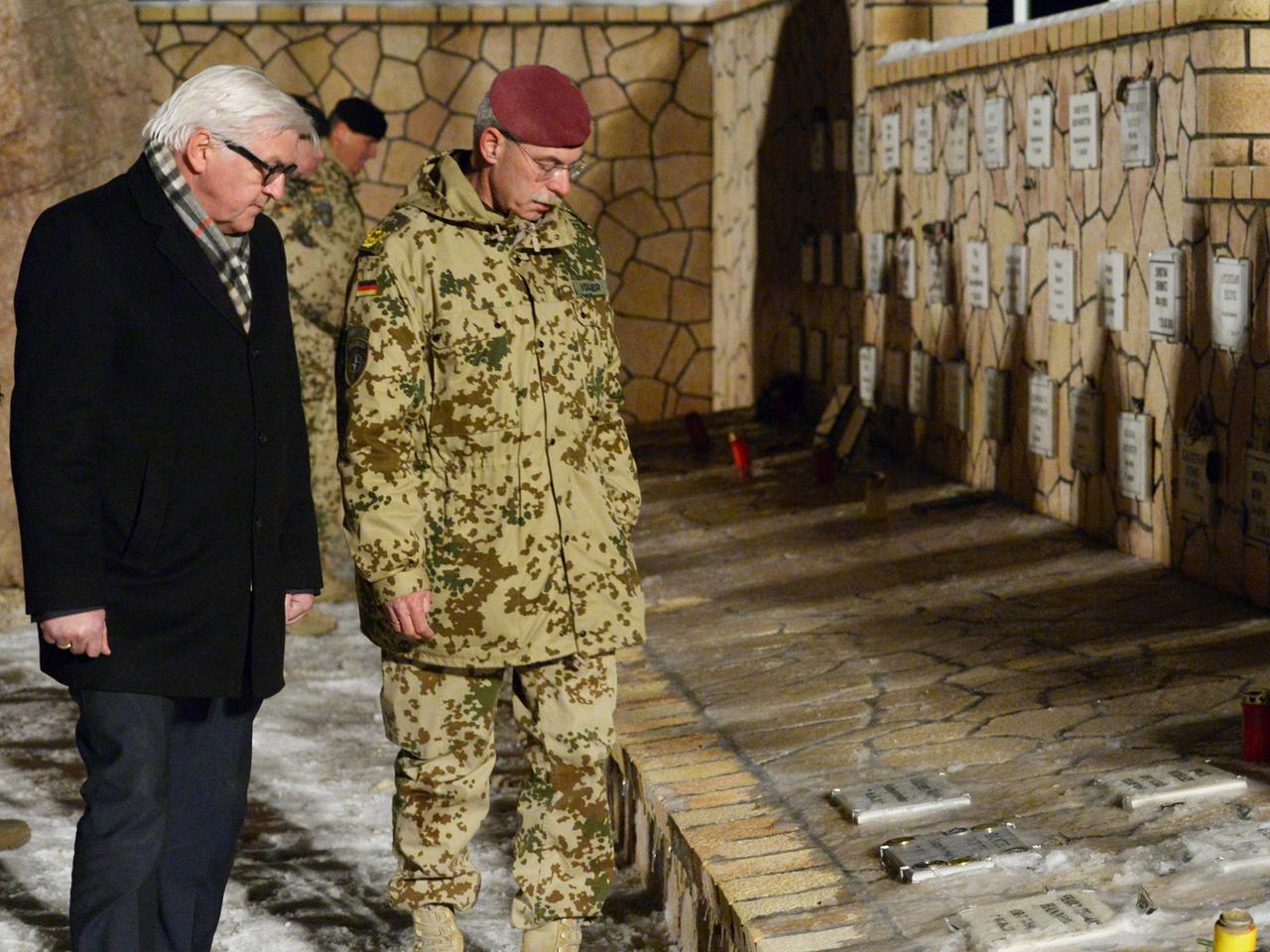 Bundesaußenminister Frank-Walter Steinmeier (SPD, l) sowie der Generalmajor und Kommandeur des ISAF-Regionalkommandos Nord, Jörg Vollmer, gedenken am 09.02.2014 im Ehrenhain im Camp Marmal in Masar-e-Scharif (Afghanistan) der gefallenen Soldaten.