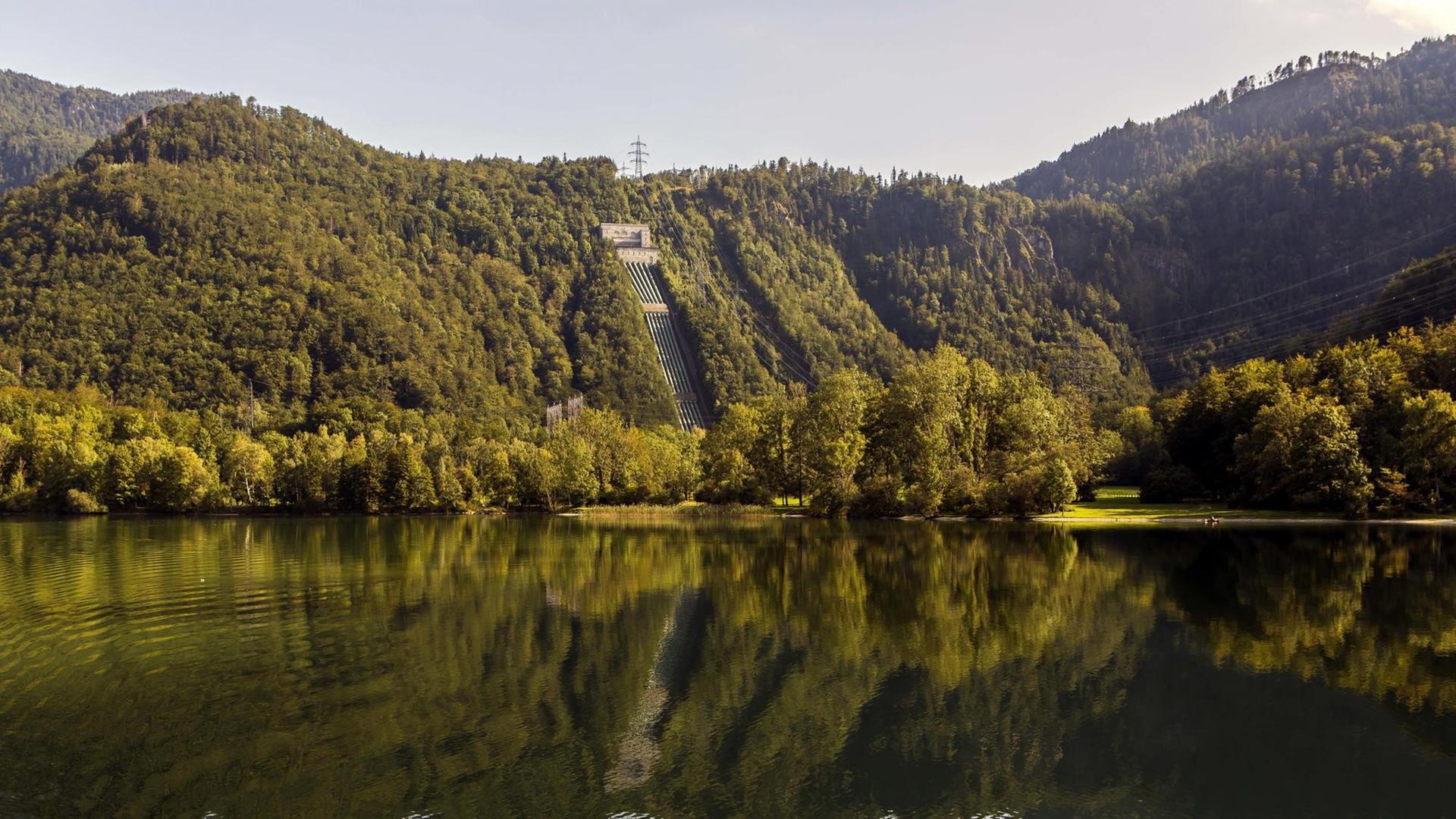 Ansicht des Walchensee-Kraftwerks direkt am See zwischen bewaldeten Hügeln gelegen. Ansicht des Walchensee-Kraftwerks direkt am See zwischen bewaldeten Hügeln gelegen.