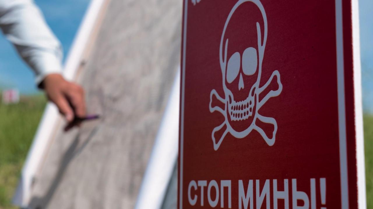 Warnschild vor Minen in russischer Sprache