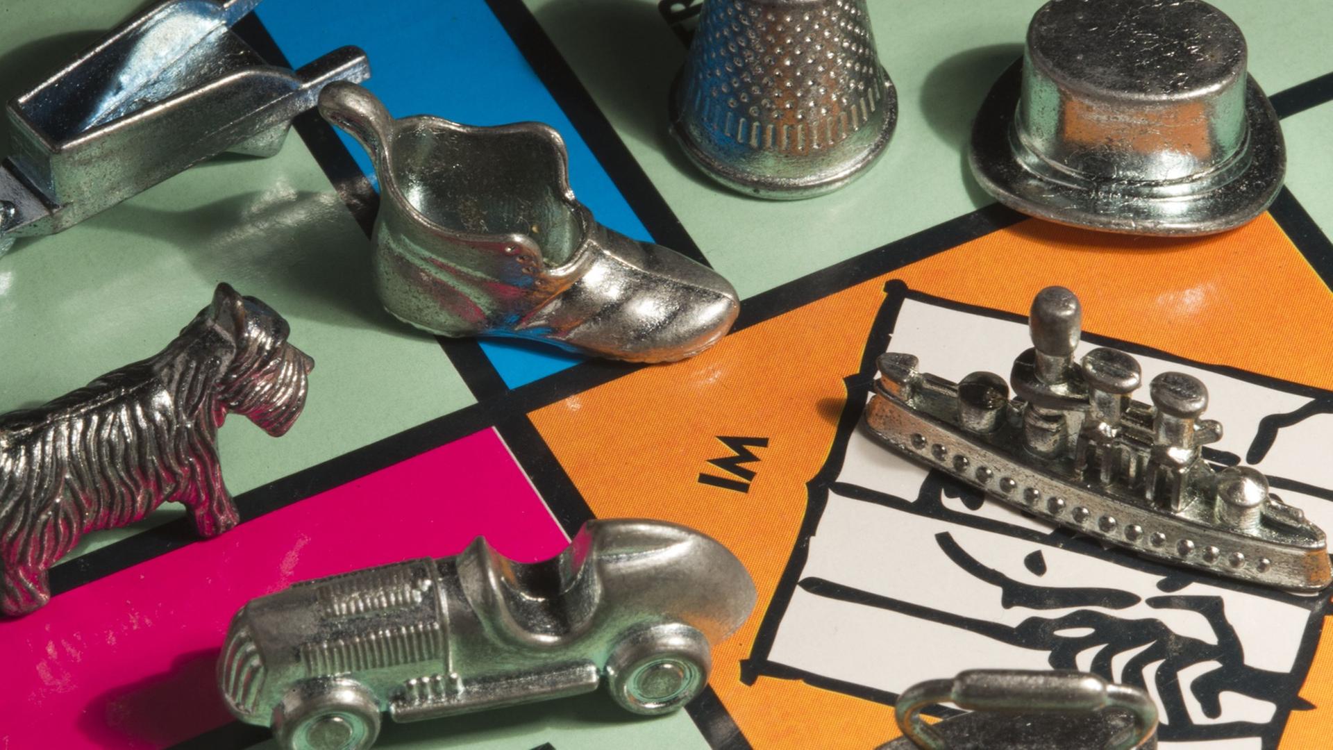Die Spielfiguren des Monopoly-Spiels sind auf dem Spielbrett zu sehen. Die Spielfiguren des Monopoly-Spiels sind auf dem Spielbrett zu sehen.