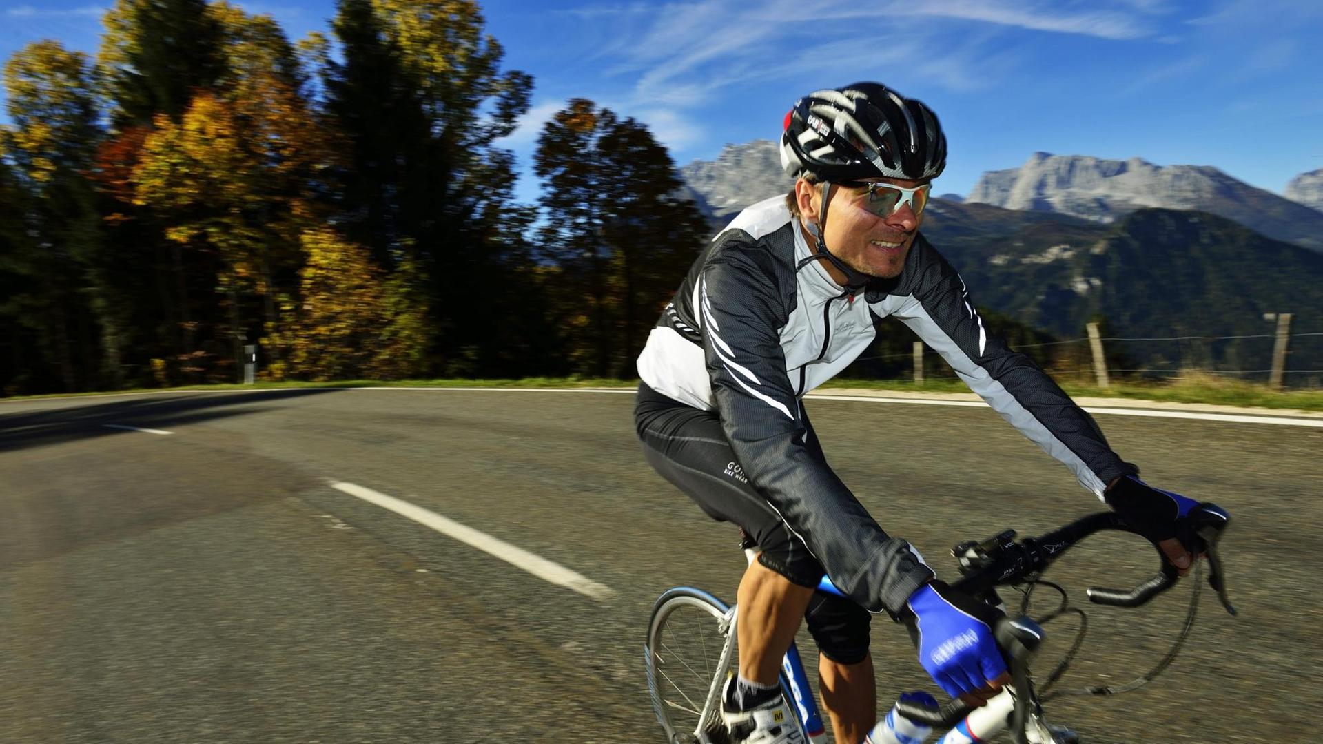 Ein Rennradfahrer in Funktionskleidung fährt auf der Obersalzbergstraße in Berchtesgaden Ein Rennradfahrer in Funktionskleidung fährt auf der Obersalzbergstraße in Berchtesgaden