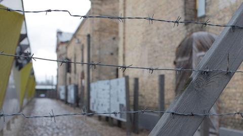 Blick durch ein Tor mit Stacheldraht in eine Gasse des Rigaer Ghetto-Museums des Vereins Shamir am 11.01.2014.