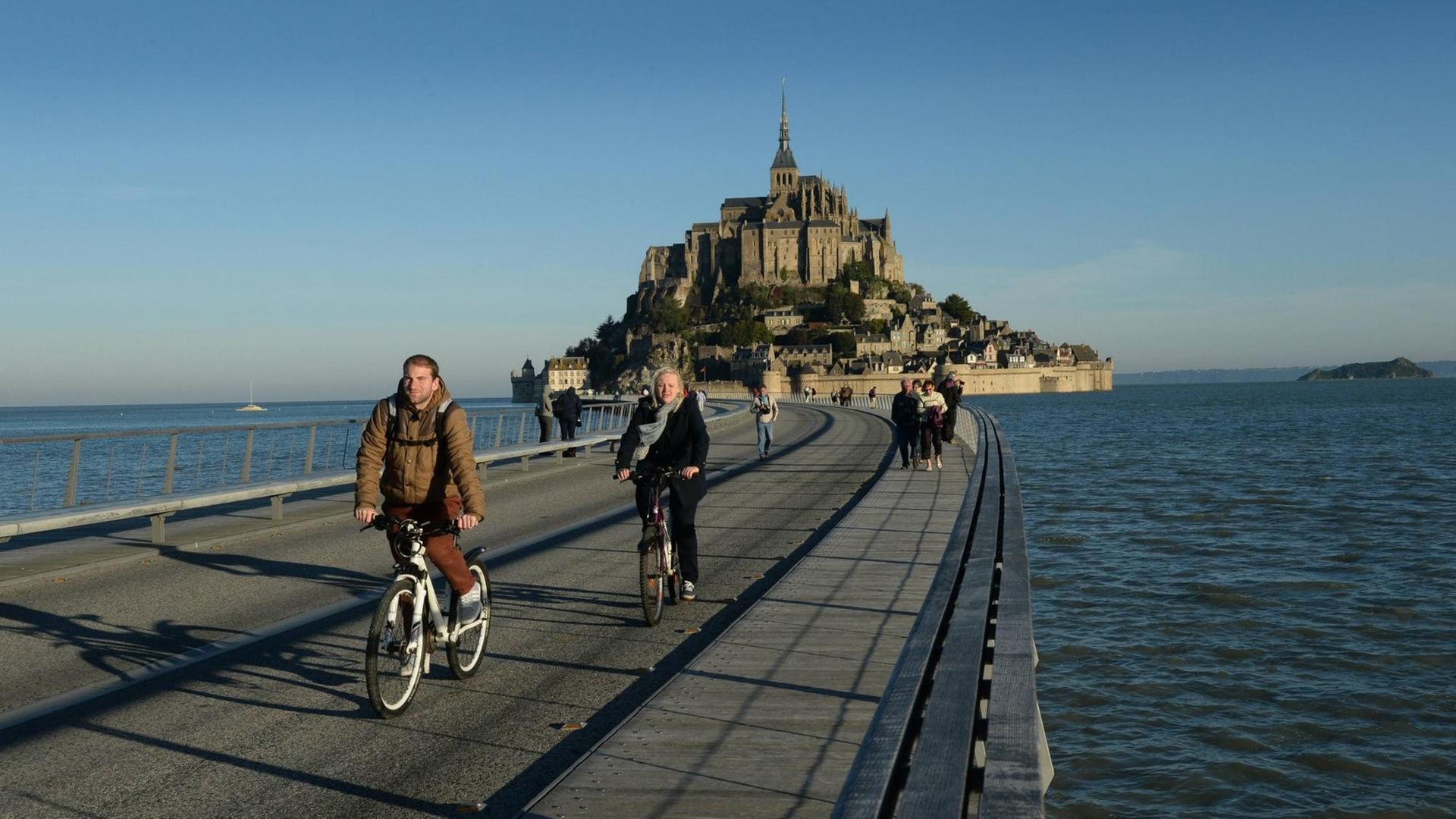 Radfahrer vor dem Mont Saint-Michel in der Normandie