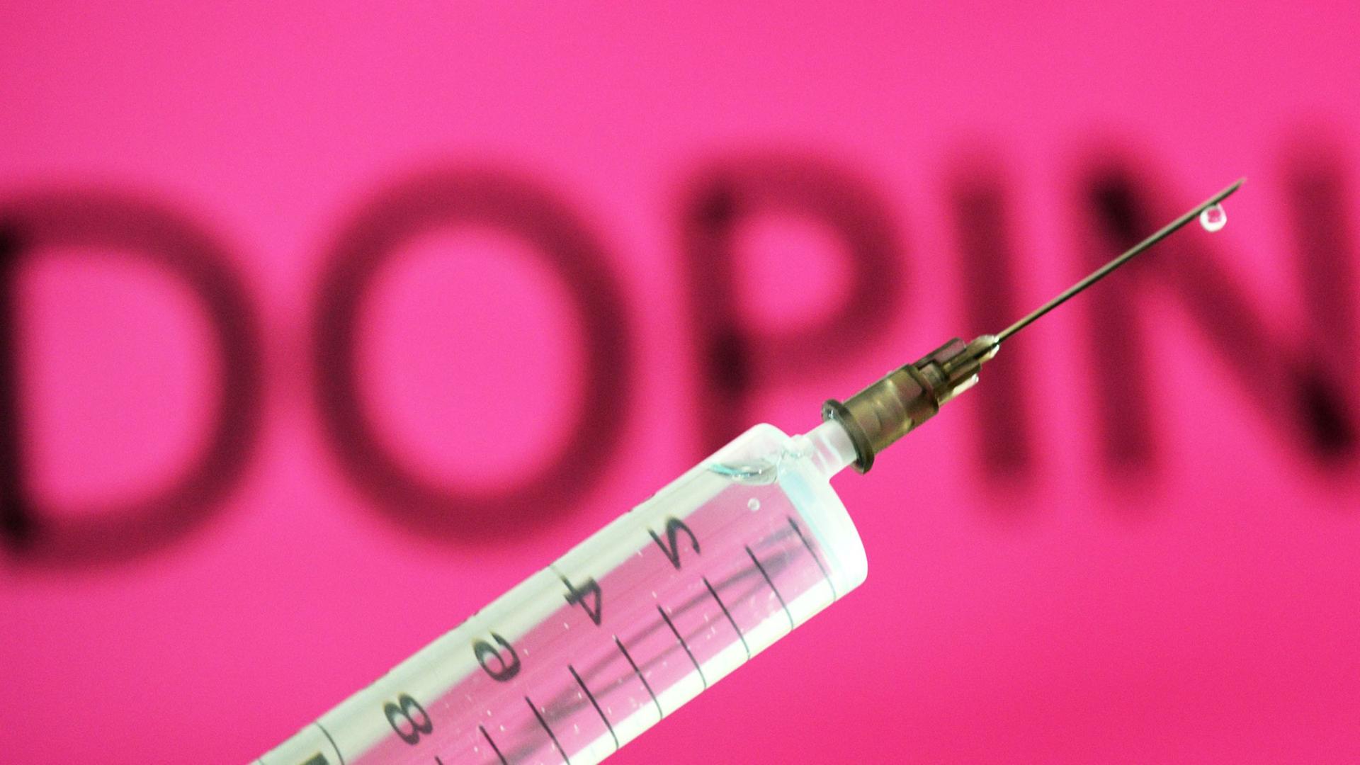 Eine Spritze vor einem pinken Schild mit der Aufschrift 'Doping'