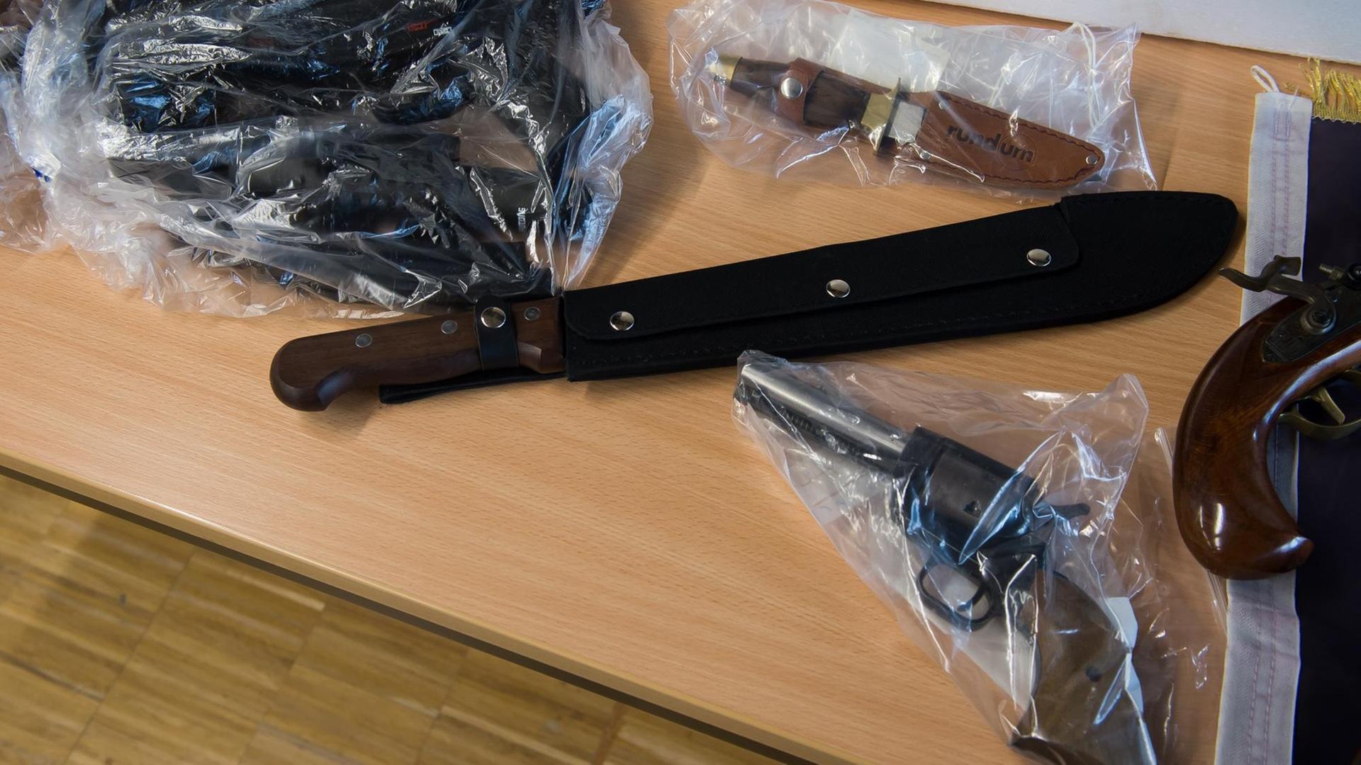 Beschlagnahmte Gegenstände liegen am 09.02.2017 während einer Pressekonferenz der Polizei in Göttingen (Niedersachsen) auf einem Tisch. Zu sehen sind eine Machete und Schusswaffen.