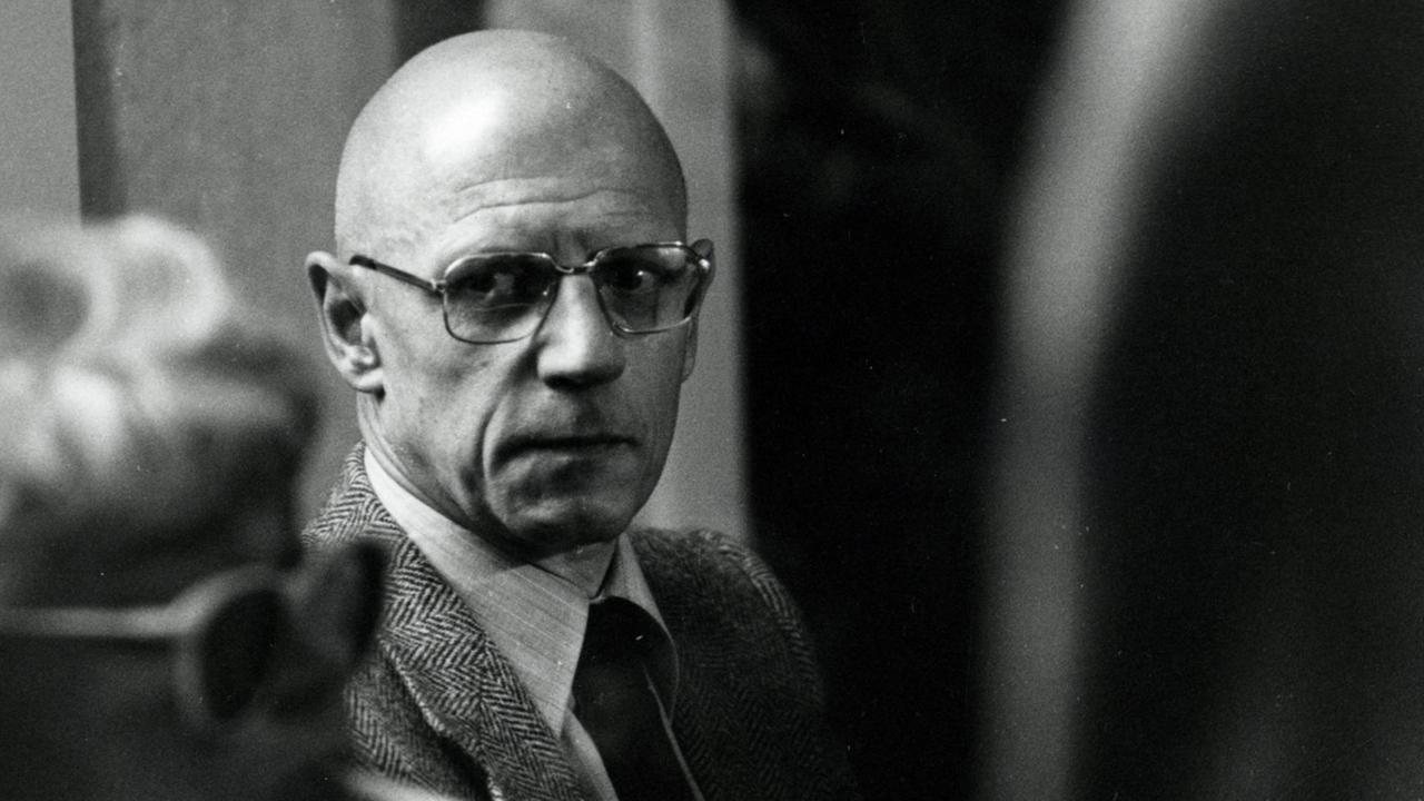 Der französische Philosoph Michel Foucault schaut aus den Augenwinkel an der Kamera vorbei. Er trägt eine große Brille. Der französische Philosoph Michel Foucault schaut aus den Augenwinkel an der Kamera vorbei. Er trägt eine große Brille.