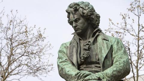 Eine Beethoven-Figur, die zwischen Bäumen steht.