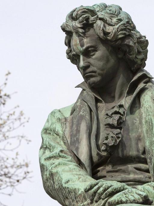 Eine Beethoven-Figur, die zwischen Bäumen steht.