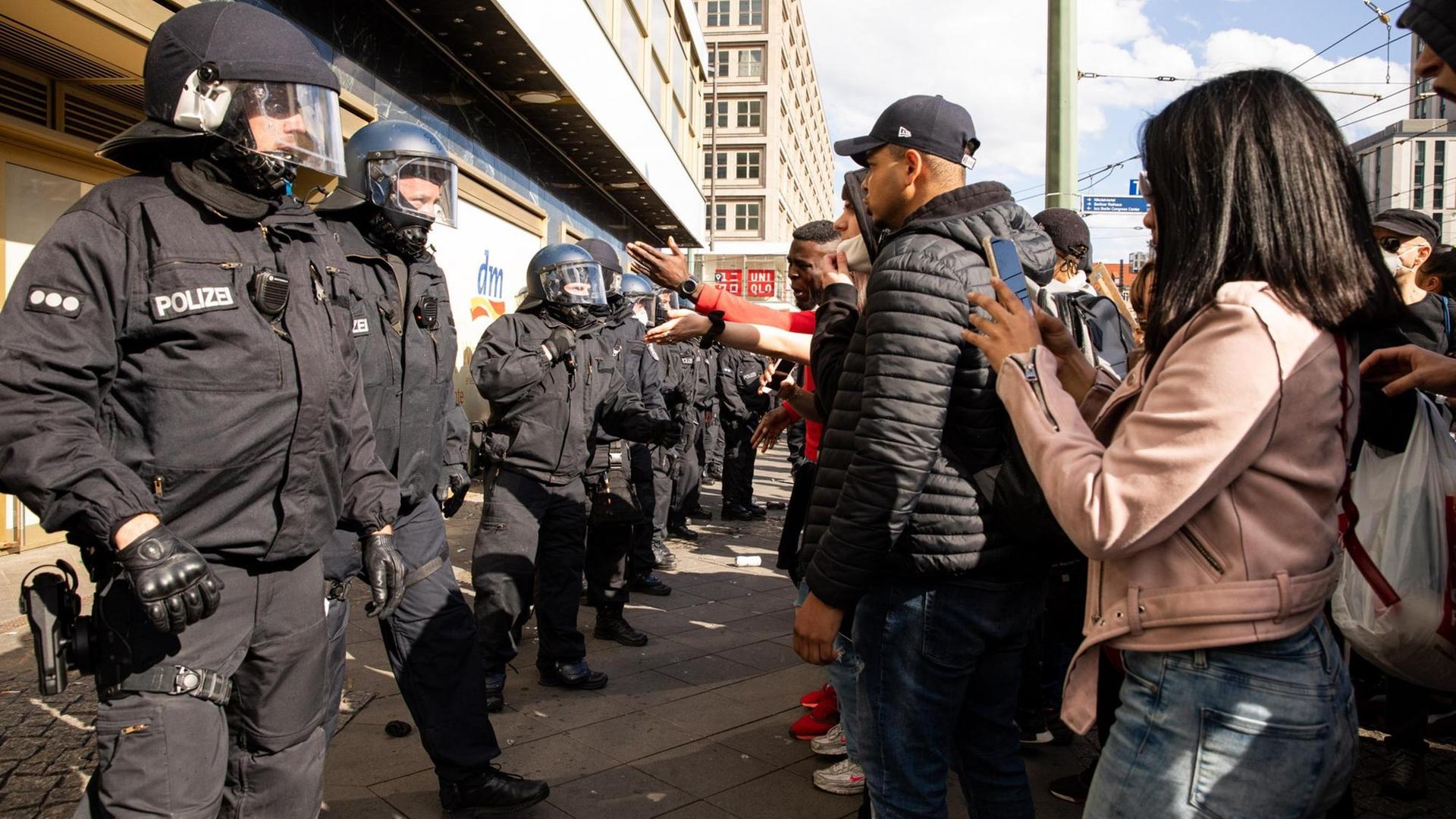 Polizisten und schwarze Demonstranten stehen sich in Berlin gegenüber. Polizisten und schwarze Demonstranten stehen sich in Berlin gegenüber.