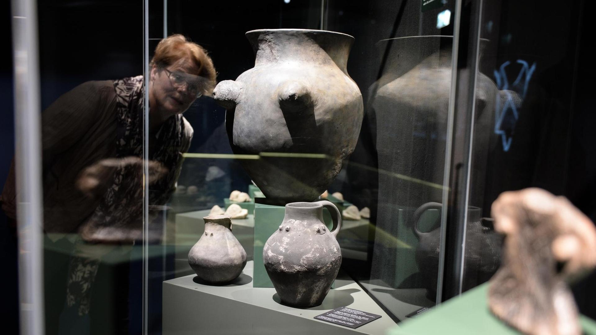 Eine Ausstellungs-Mitarbeiterin posiert im Kloster in Bad Schussenried (Baden-Württemberg) an einem Keramik-Gefäß mit Brustapplikationen (4000 bis 3750 vor Christus). Eine Ausstellungs-Mitarbeiterin posiert im Kloster in Bad Schussenried (Baden-Württemberg) an einem Keramik-Gefäß mit Brustapplikationen (4000 bis 3750 vor Christus).