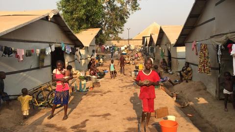 Blick in das Lager Benz-Vi in Bangui, der Hauptstadt der Zentralafrikanischen Republik, in dem auf einer Fläche von etwa zwei großen deutschen Supermärkten mehr als 2600 Binnenflüchtlinge leben. Auf unbefestigtem Boden stehen Zelte, davor mehrere Kinder und Frauen.