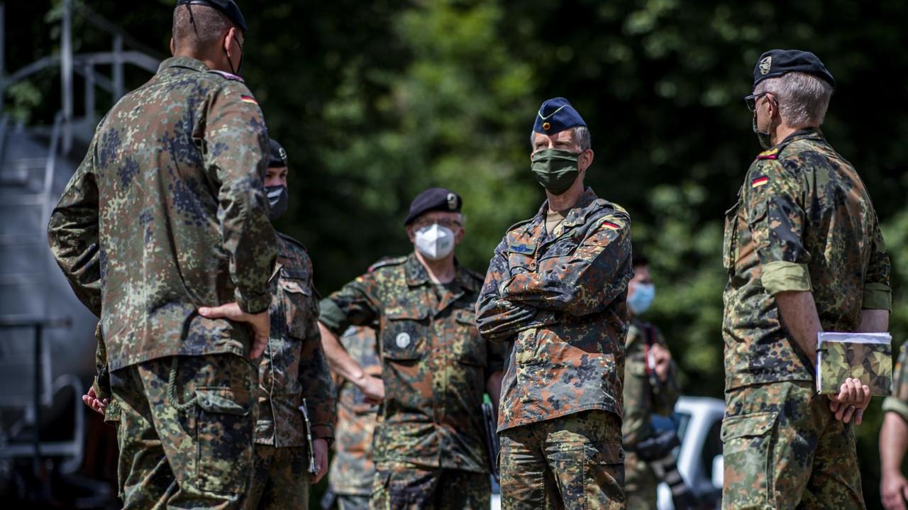 Bundeswehrsoldaten stehen mit Corona-Schutzmasken
