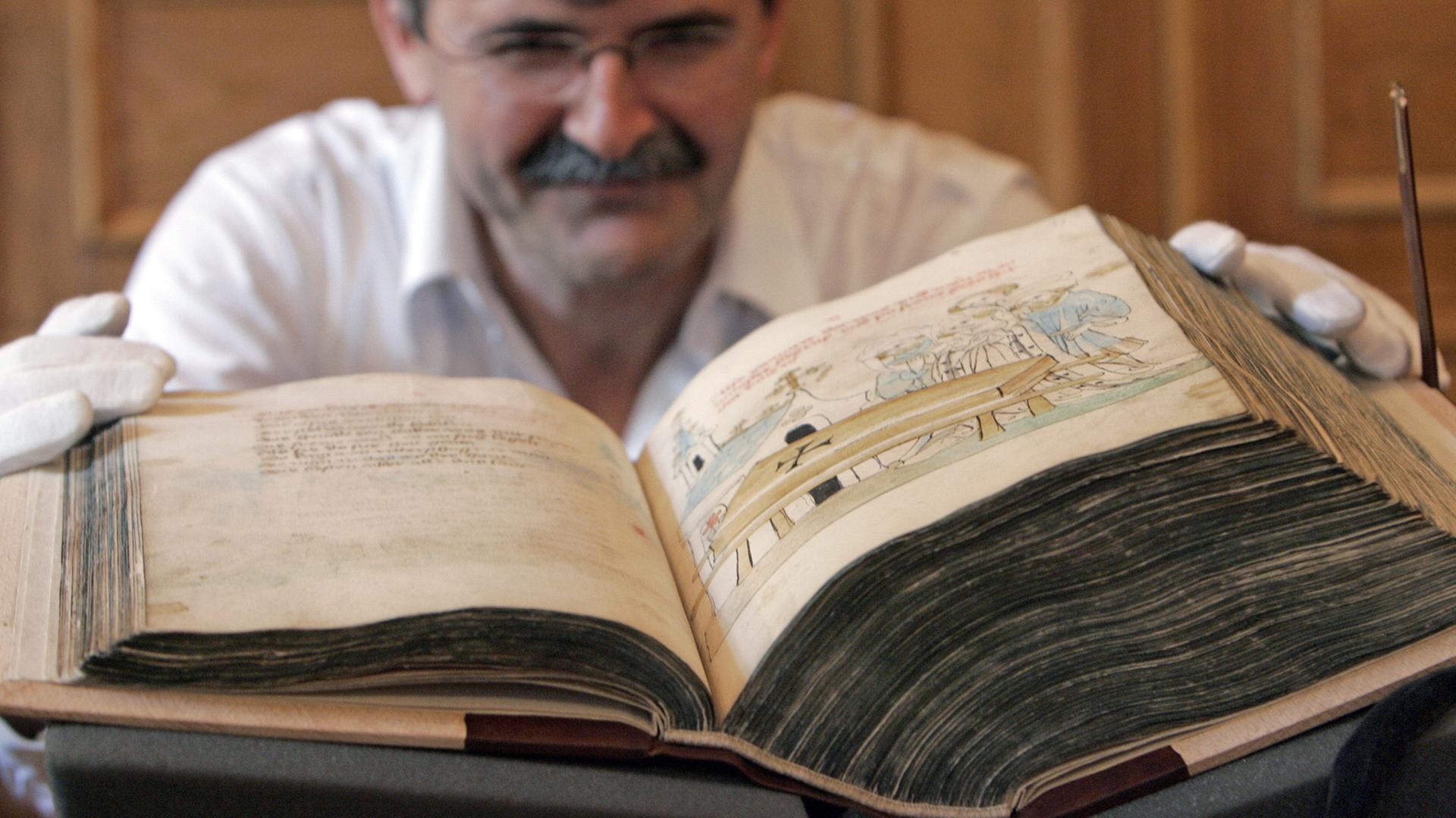 Den "Parzival" von Wolfram von Eschenbach zeigt Werner Hoffmann von der Universitätsbibliothek Leipzig während einer Präsentation mittelalterlicher Handschriften am Dienstag (12.08.2008) in Leipzig. Der Gralsroman entstand zu Beginn des 13. Jahrhunderts und ist in dieser handschriftlichen Fassung aus der Mitte des 15. Jahrhunderts 550 Seiten stark. Die Handschrift wurde wie weitere Stücke aus der kurfürstlichen, später königlich-sächsischen Bibliothek im Rahmen eines Forschungsprojektes in Leipzig digitalisiert und wissenschaftlich ausgewertet. Den "Parzival" von Wolfram von Eschenbach zeigt Werner Hoffmann von der Universitätsbibliothek Leipzig während einer Präsentation mittelalterlicher Handschriften am Dienstag (12.08.2008) in Leipzig. Der Gralsroman entstand zu Beginn des 13. Jahrhunderts und ist in dieser handschriftlichen Fassung aus der Mitte des 15. Jahrhunderts 550 Seiten stark. Die Handschrift wurde wie weitere Stücke aus der kurfürstlichen, später königlich-sächsischen Bibliothek im Rahmen eines Forschungsprojektes in Leipzig digitalisiert und wissenschaftlich ausgewertet.