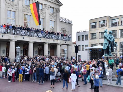 Mit der Nachstellung eines historischen Fotos auf dem Theaterplatz beginnt die Uraufführung "Reichstags-Reenactment" beim Kunstfest Weimar.