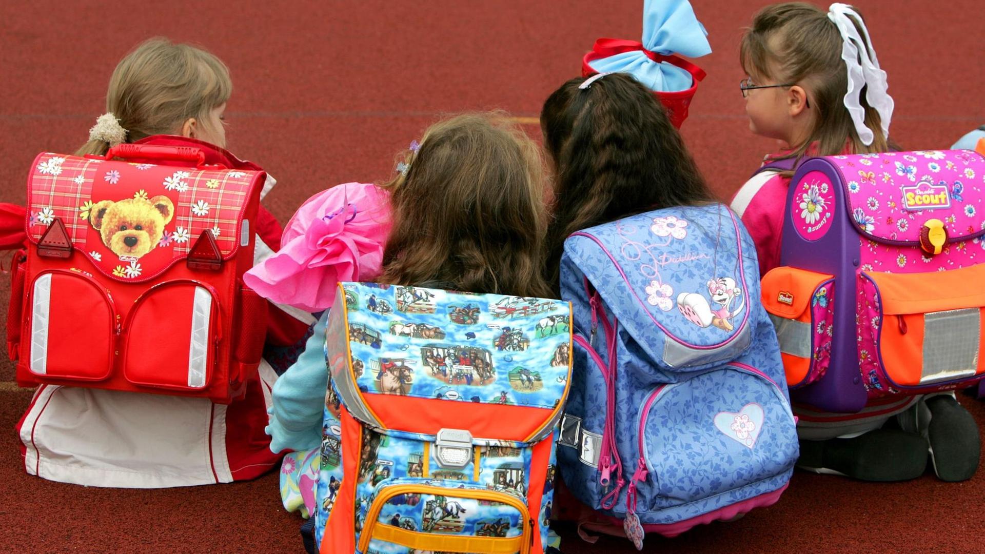 Schulanfänger mit ihren Ranzen sitzen auf dem Schulhof der Gemeinschaftsgrundschule in Düsseldorf. Schulanfänger mit ihren Ranzen sitzen auf dem Schulhof der Gemeinschaftsgrundschule in Düsseldorf.