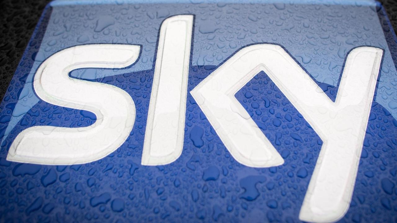 Das Logo des Fernsehunternehmens Sky ist auf der verregneten Motorhaube eines Autos zu sehen.