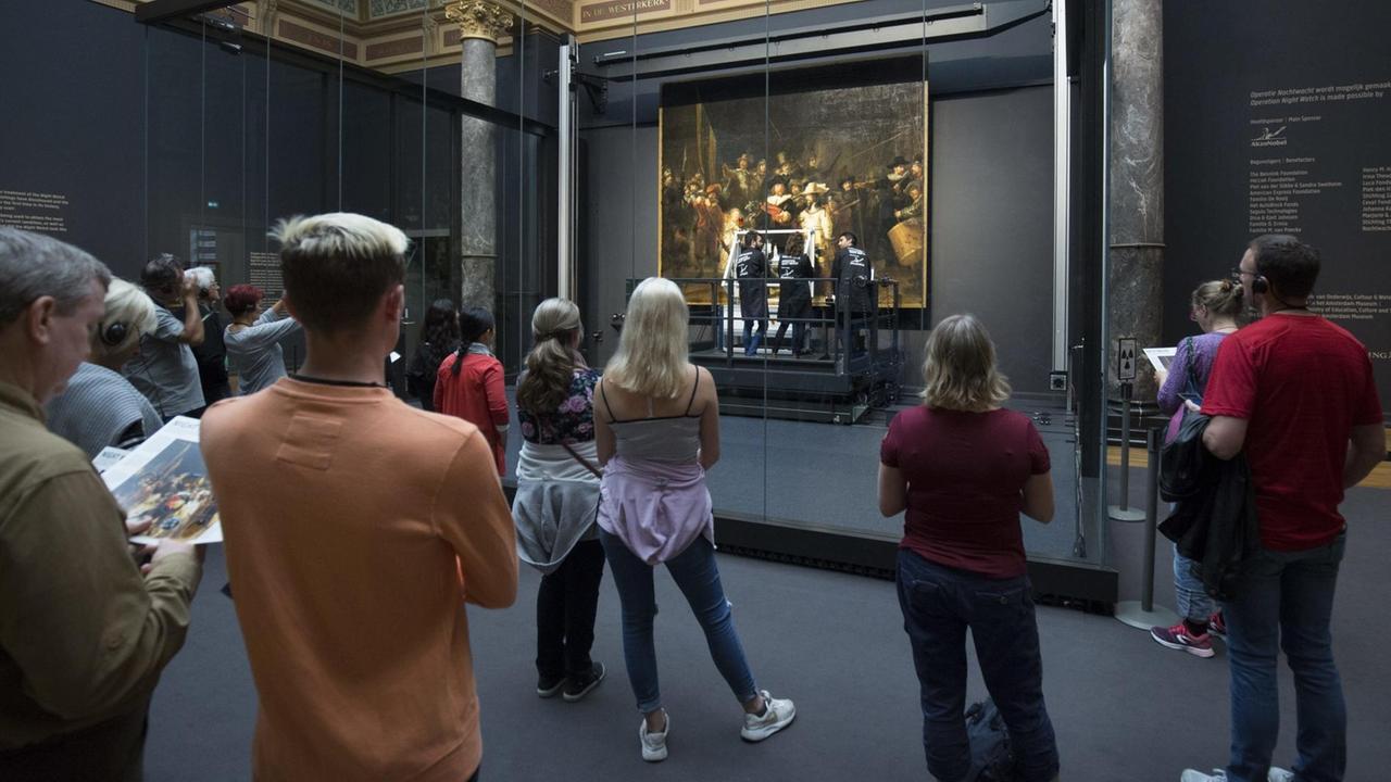 Zuschauer betrachten Rembrandts "Nachtwache", während das berühmte Bild gerade im Rijksmuseum in Amsterdam restauriert wird. Zuschauer betrachten Rembrandts "Nachtwache", während das berühmte Bild gerade im Rijksmuseum in Amsterdam restauriert wird.