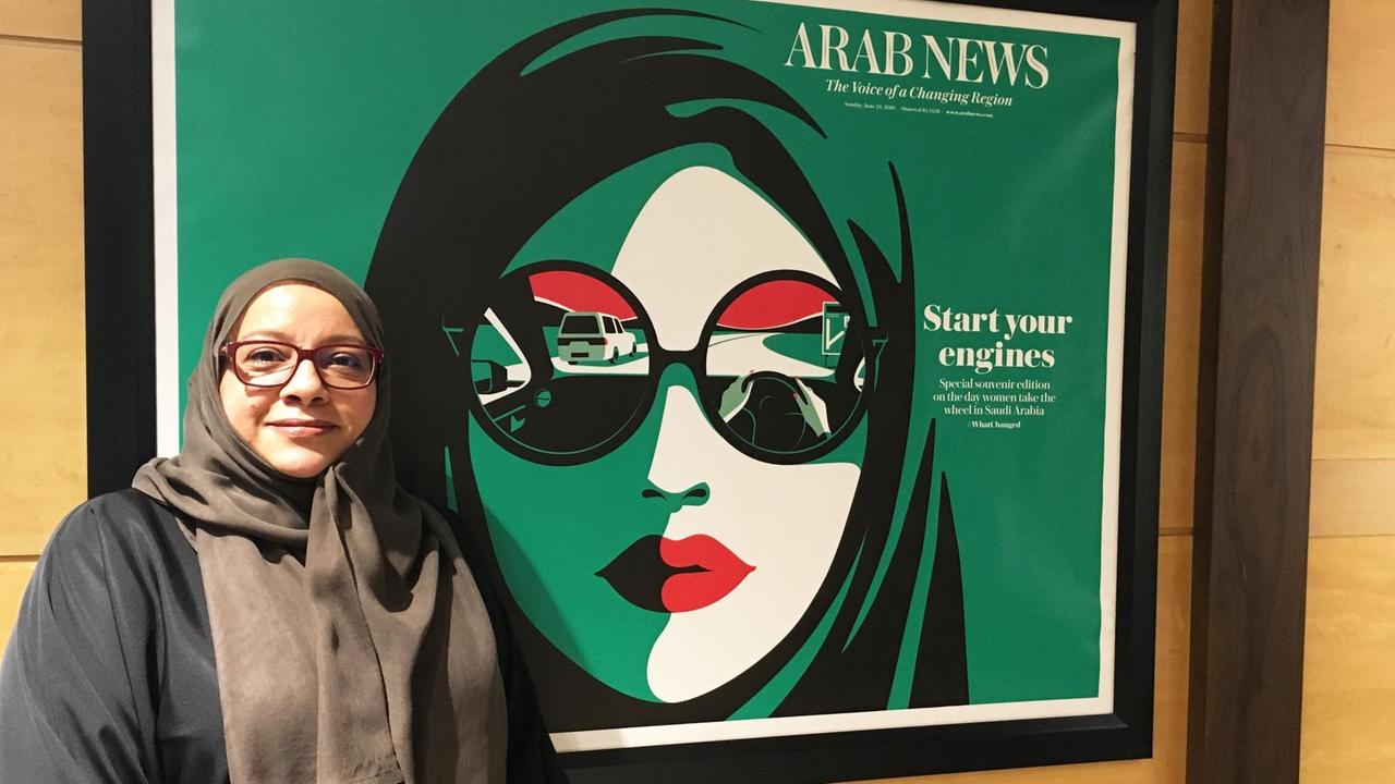 Für Journalistin Somayya Jabarti war die Aufhebung des Fahrverbots für Frauen ein entscheidender Schritt. Eine Frau steht vor einem Plakat.