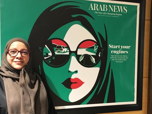 Für Journalistin Somayya Jabarti war die Aufhebung des Fahrverbots für Frauen ein entscheidender Schritt. Eine Frau steht vor einem Plakat.
