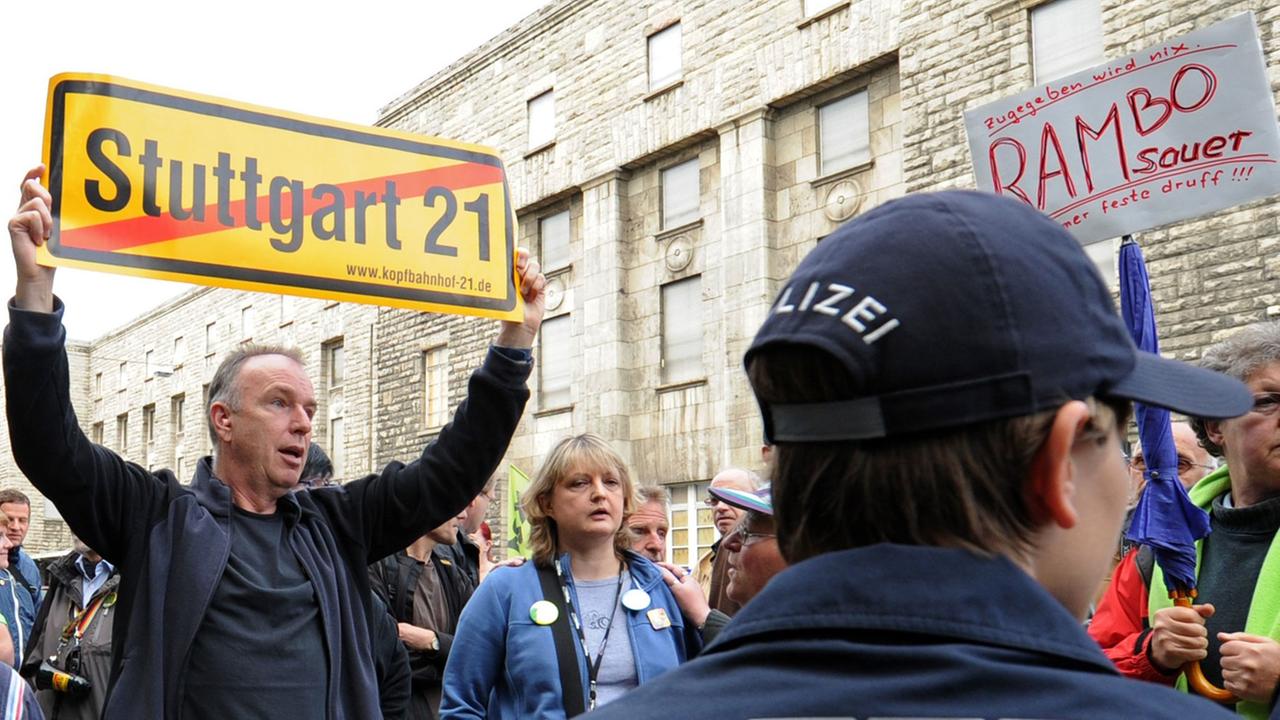 Stuttgart 21-Gegner demonstrieren in Stuttgart vor einem Bautor, im Hintergrund ist der Südflügel des Hauptbahnhofes zu sehen. Stuttgart 21-Gegner demonstrieren in Stuttgart vor einem Bautor, im Hintergrund ist der Südflügel des Hauptbahnhofes zu sehen.