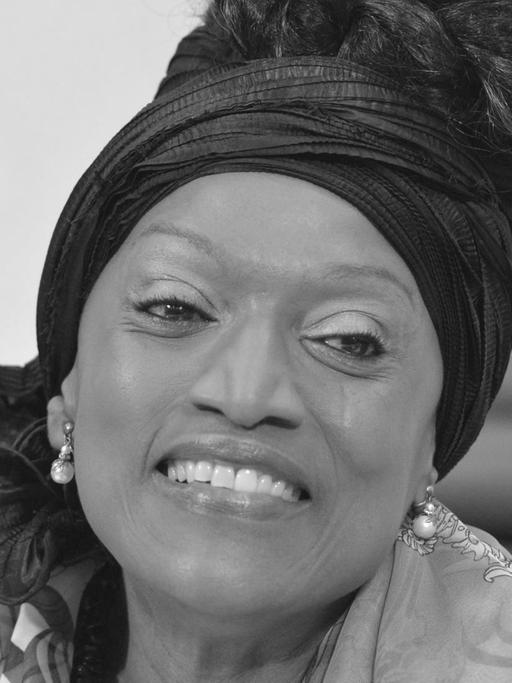 Die Opernsängerin Jessye Norman lächelt bei einer Pressekonferenz im Jahr 2012 in die Kamera. Ihre schwarzen Haare sind mit einem Stirnband nach obend gebunden.