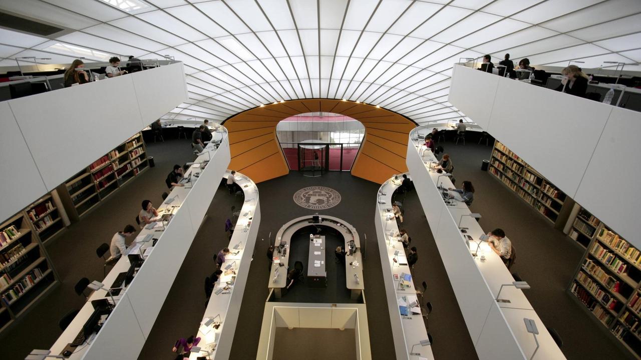 Studierende sitzen in der Bibliothek der Philologischen Fakultät der FU Berlin und lernen.