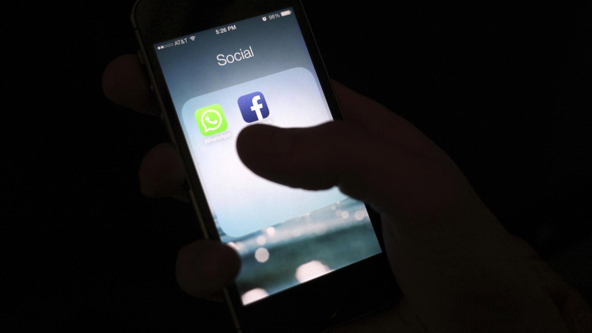 Blick auf einen Smartphone-Bildschirm mit dem Icon der Facebook-App Blick auf einen Smartphone-Bildschirm mit dem Icon der Facebook-App
