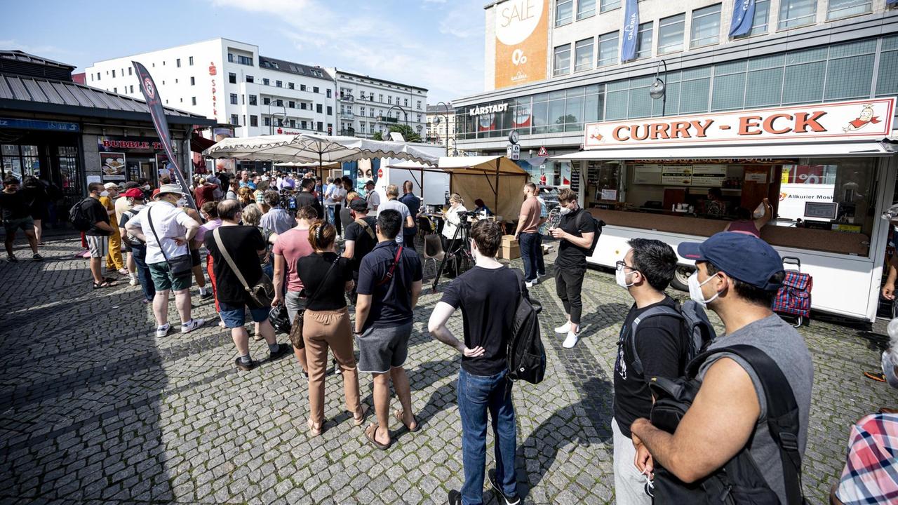 Menschen warten in der Schlange eines mobilen Impfteams auf dem Hermannplatzin Berlin. Menschen warten in der Schlange eines mobilen Impfteams auf dem Hermannplatzin Berlin.