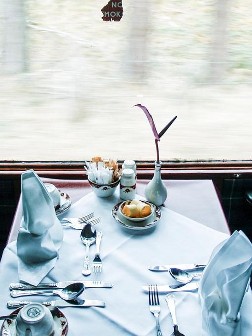 Blick auf einen gedeckten Tisch an einem Fenster im Zug