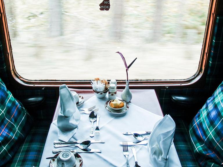 Blick auf einen gedeckten Tisch an einem Fenster im Zug