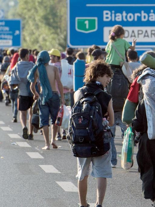 Hunderte Flüchtlinge laufen bei Budapest über eine Autobahn in Richtung der österreichischen Grenze.