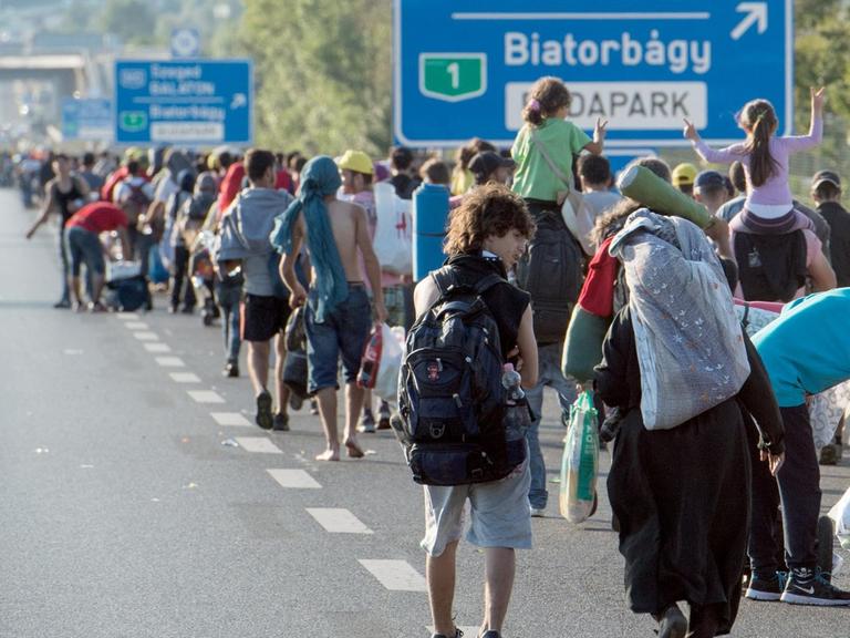 Hunderte Flüchtlinge laufen bei Budapest über eine Autobahn in Richtung der österreichischen Grenze.