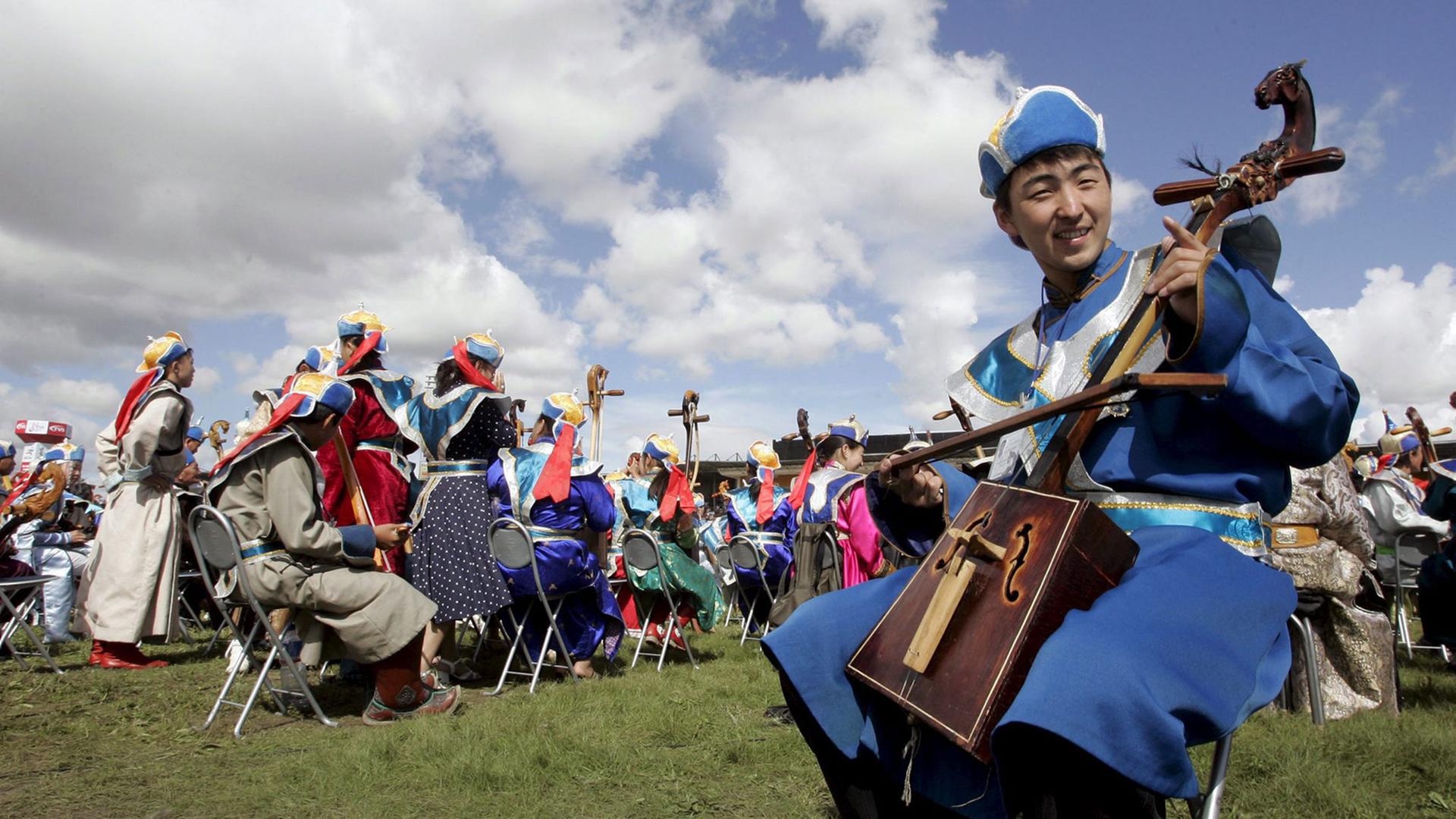 Ein Mann spielt eine traditionelle mongolische Pferdekopfgeige.