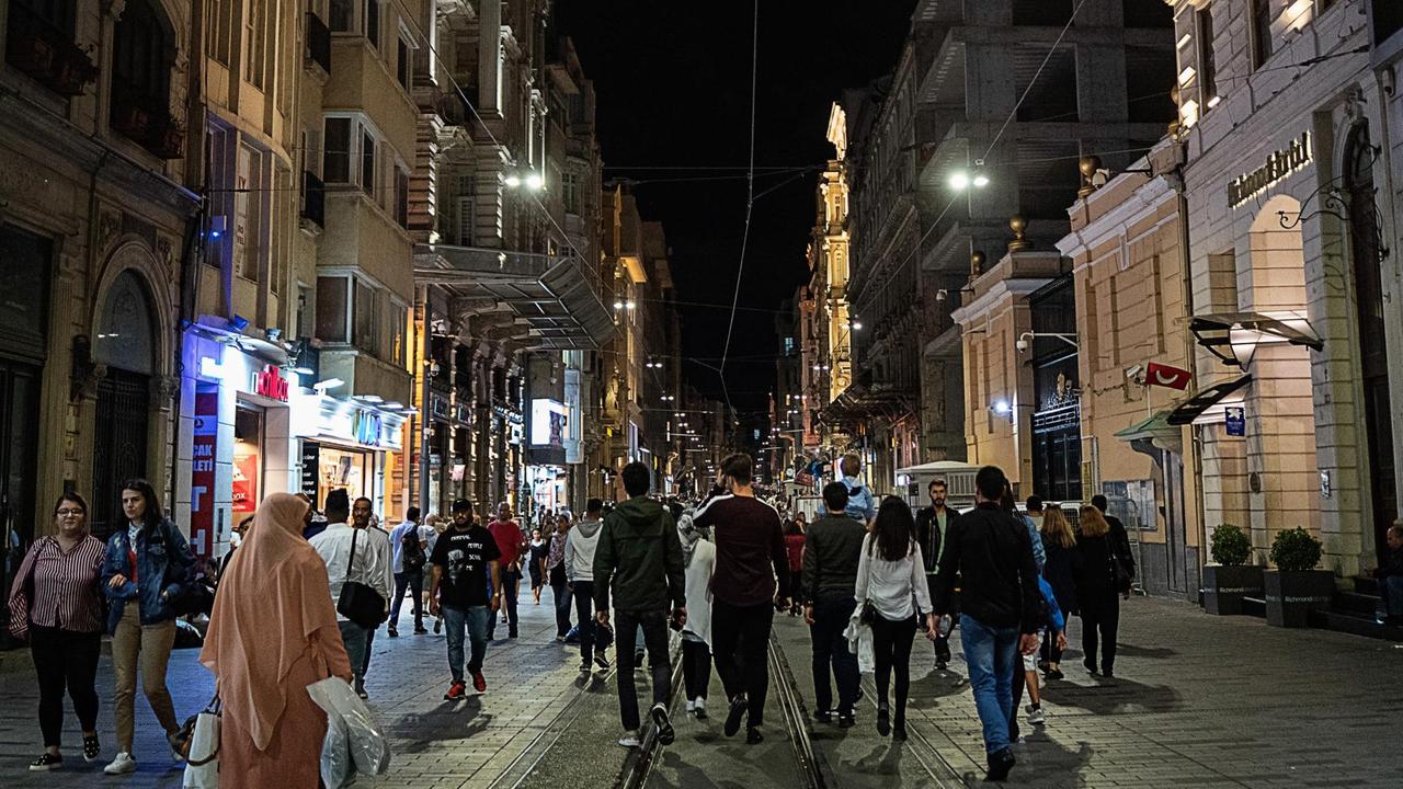 Blick in die Einkaufsstrasse Istiklal im Zentrum von Istanbul, auf der abends Menschen unterwegs sind.