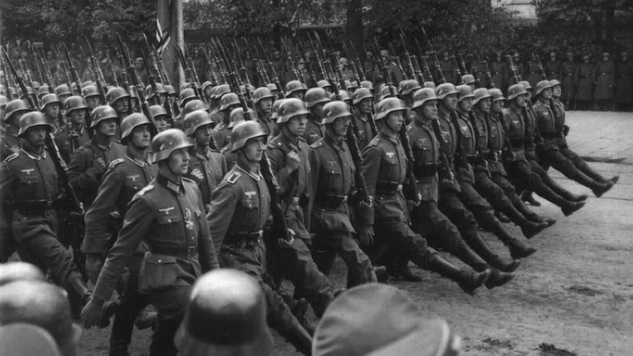 Ein historisches Schwarz-weiß-Foto zeigt Wehrmachtsoldaten bei einer Parade in Waschau in Polen im September 1936.