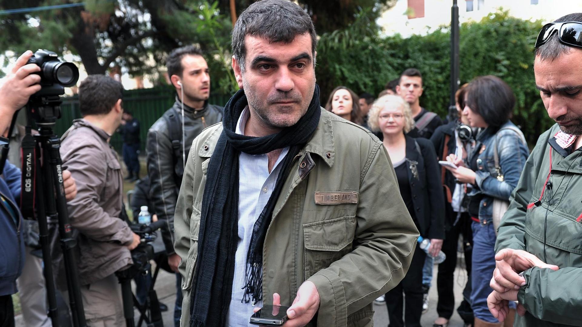 Costas Vaxevanis steht im Kreis griechischer Medienleute und wartet auf den Beginn seines Prozesses am 1. November 2012. Costas Vaxevanis steht im Kreis griechischer Medienleute und wartet auf den Beginn seines Prozesses am 1. November 2012.
